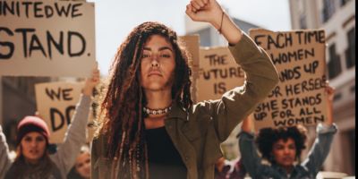 Person with raised fist during protest/ shutterstock